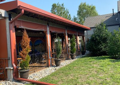 A patio with a red roof and red gutters