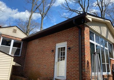 A red brick building with dark brown gutters