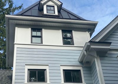 A large blue and white house with white gutters