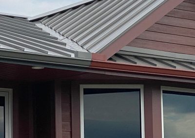 Gutters painted to match split colors on a roof: half gray, half mahogany