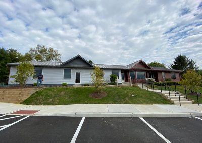 A building with two distinct halves: one with pale blue paneling, one with mahogany paneling