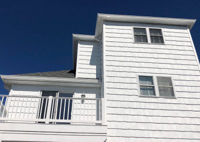 Ground's-eye view of a white building with white gutters