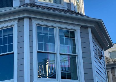 A close-up on a grey house with white gutters