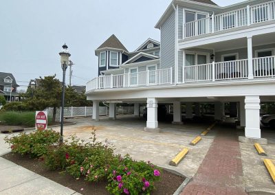 A powder-blue building with a white balcony and white gutters