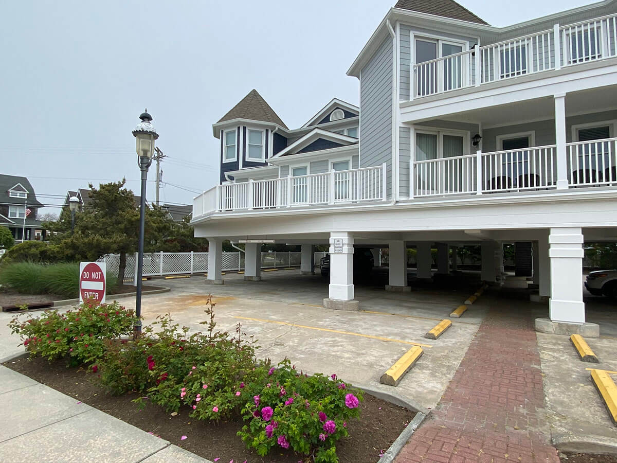 A powder-blue building with a white balcony and white gutters