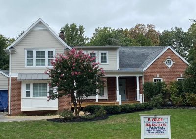 A two-story brick house with white gutters